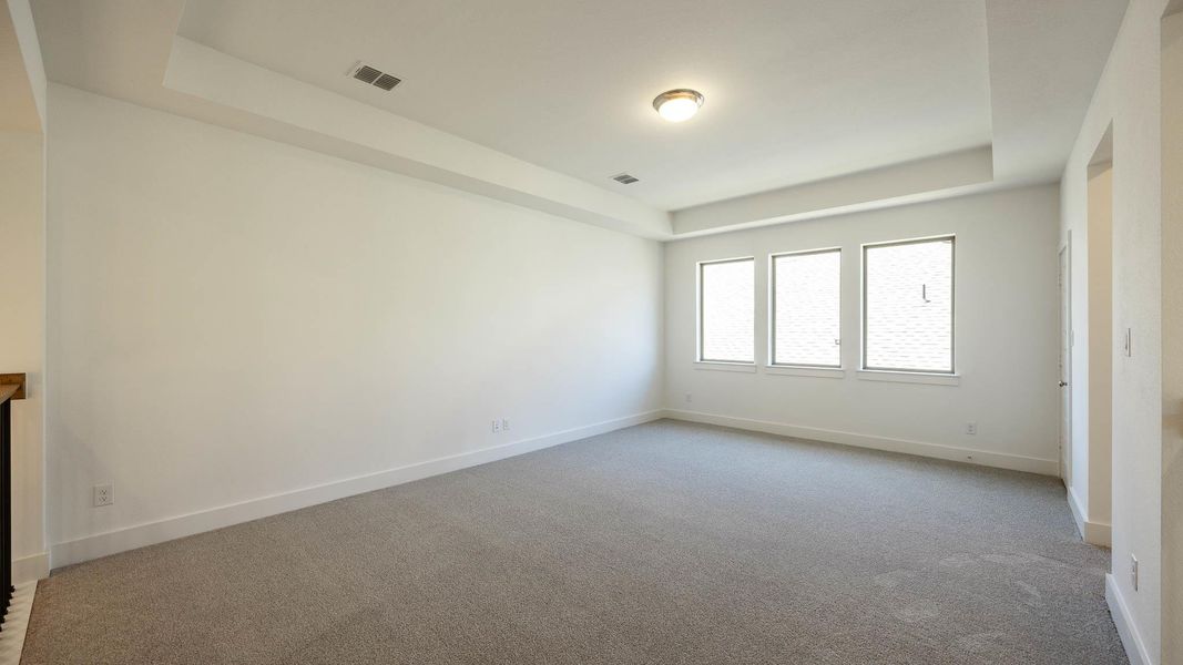 Carpeted empty room with a tray ceiling Carpeted empty room with a tray ceiling