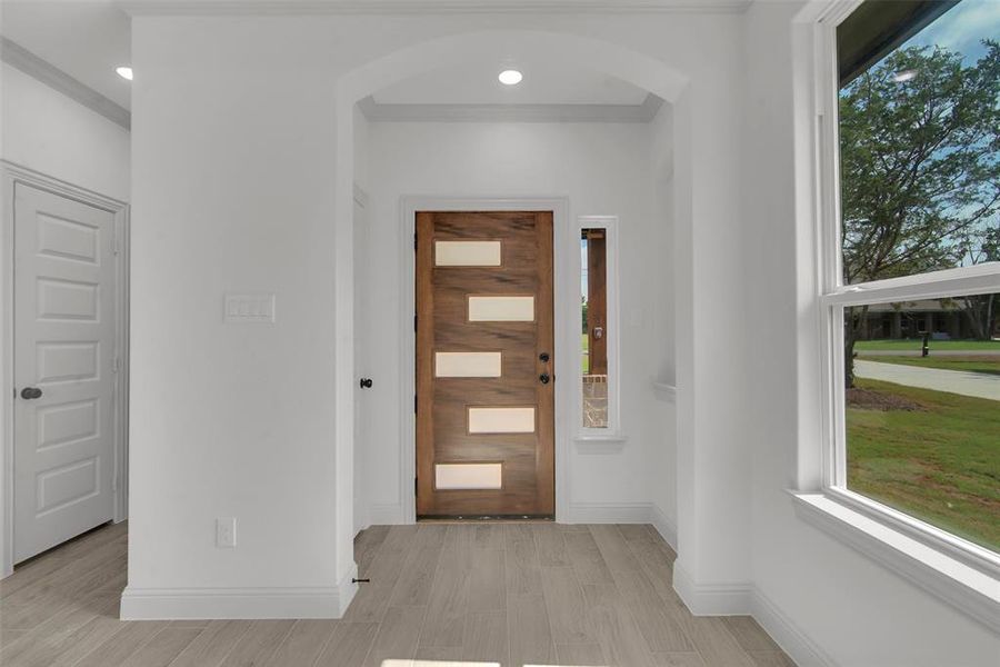 Entrance foyer featuring plenty of natural light, arched walkways, light wood finished floors, and recessed lighting Entrance foyer featuring plenty of natural light, arched walkways, light wood finished floors, and recessed lighting