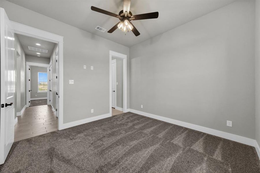 bedroom 3 with dark colored carpet and ceiling fan