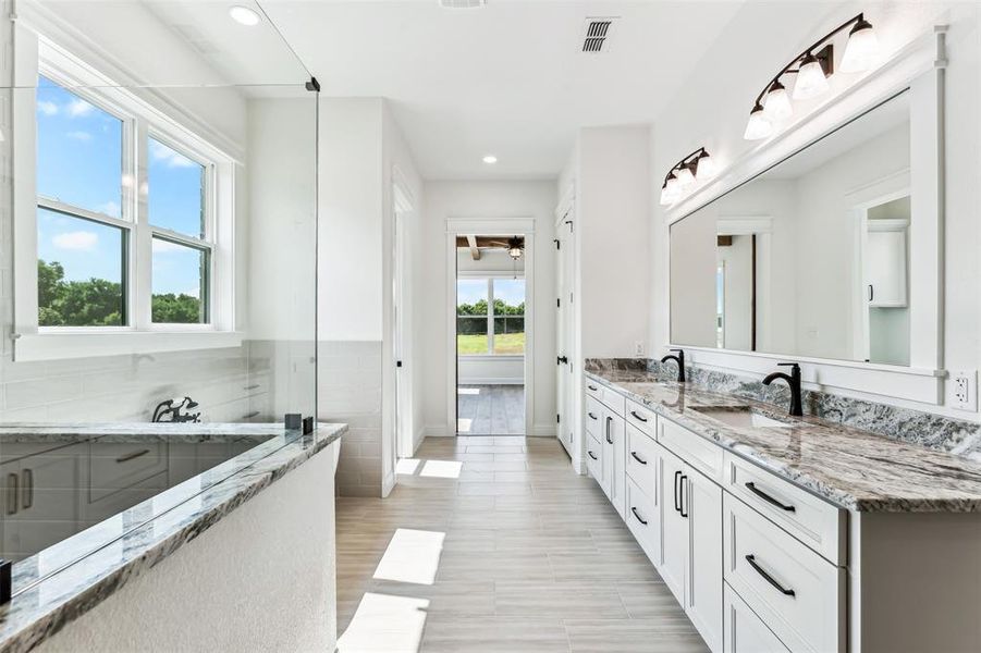 Bathroom with vanity, a washtub, and hardwood / wood-style floors