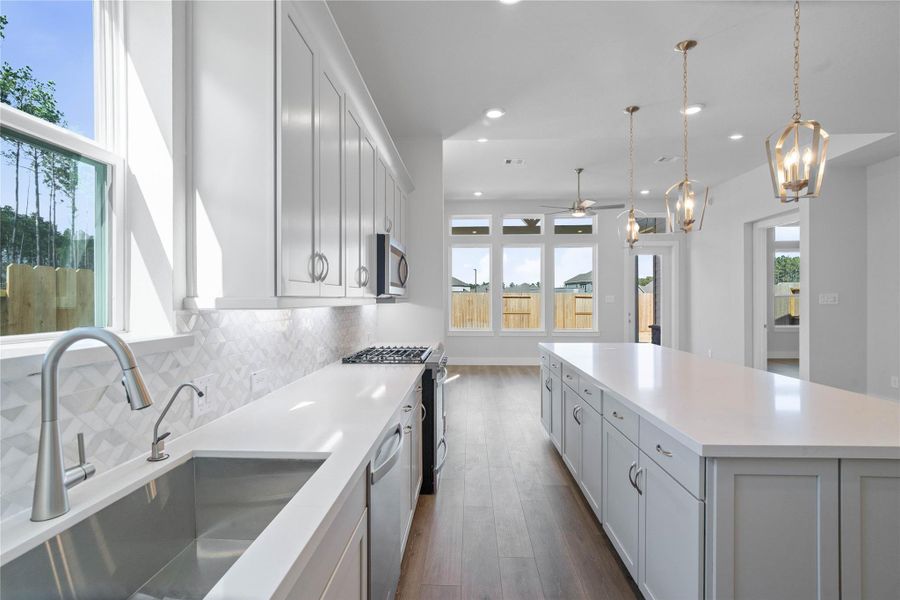 Welcome to the heart of the home, a modern, highly functional kitchen that perfectly balances style and utility. Quartz countertops, complemented by a stylish backsplash, shaker-style cabinets provide ample storage, and the Whirlpool stainless steel appliances are all features of this beautiful kitchen!