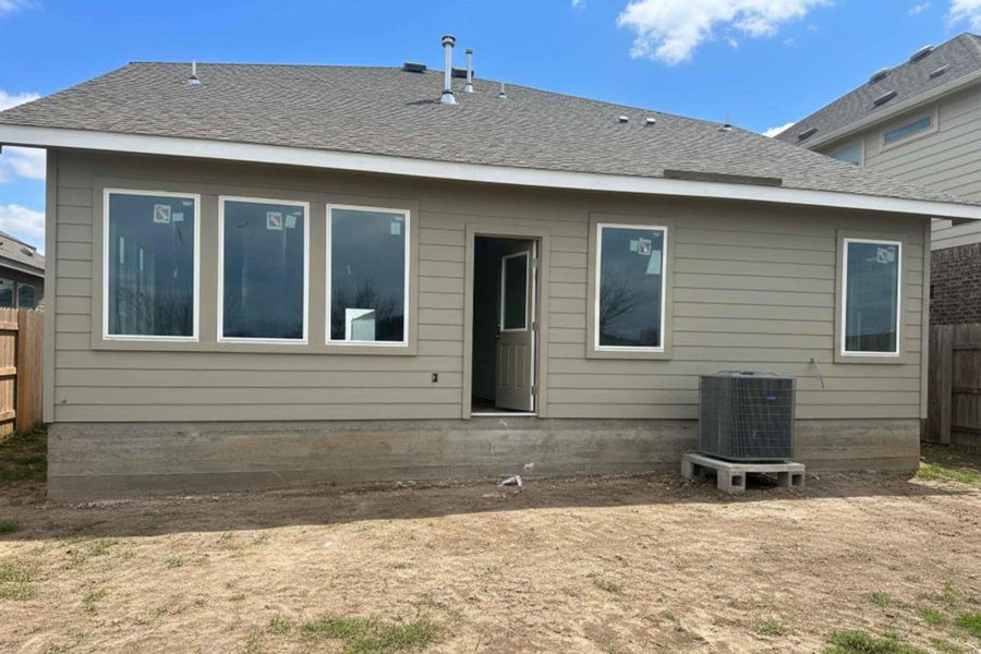 Back of property featuring a shingled roof