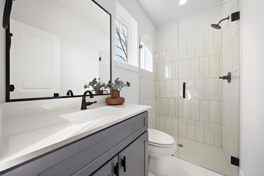 Modern first-floor bathroom featuring a sleek vanity, spacious shower, and elegant fixtures.