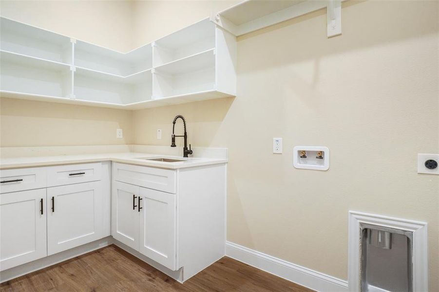 Laundry room featuring washer hookup, hardwood / wood-style flooring, electric dryer hookup, and sink