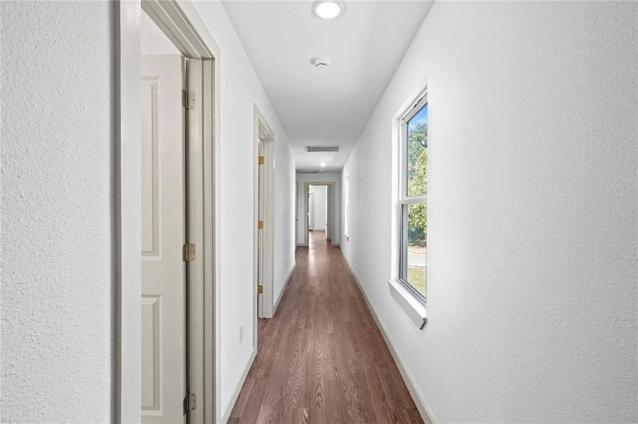Hall with dark wood-type flooring and recessed lighting