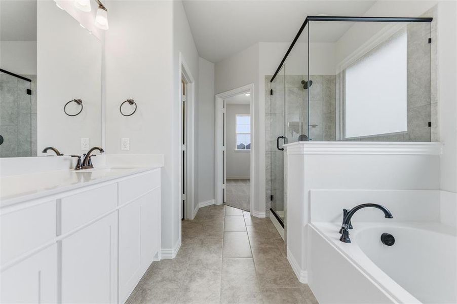 Full bathroom with vanity, a stall shower, a garden tub, and light tile patterned floors