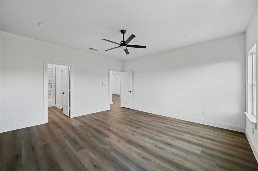 Unfurnished bedroom featuring dark hardwood / wood-style floors and ceiling fan