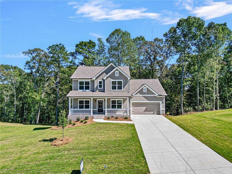 Front exterior of a new home in Woodland Hills, Loganville, GA, highlighting curb appeal (Image 1).