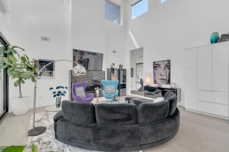 Living room with a high ceiling and light wood-type flooring