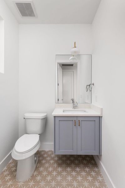 Half bath featuring vanity and baseboards