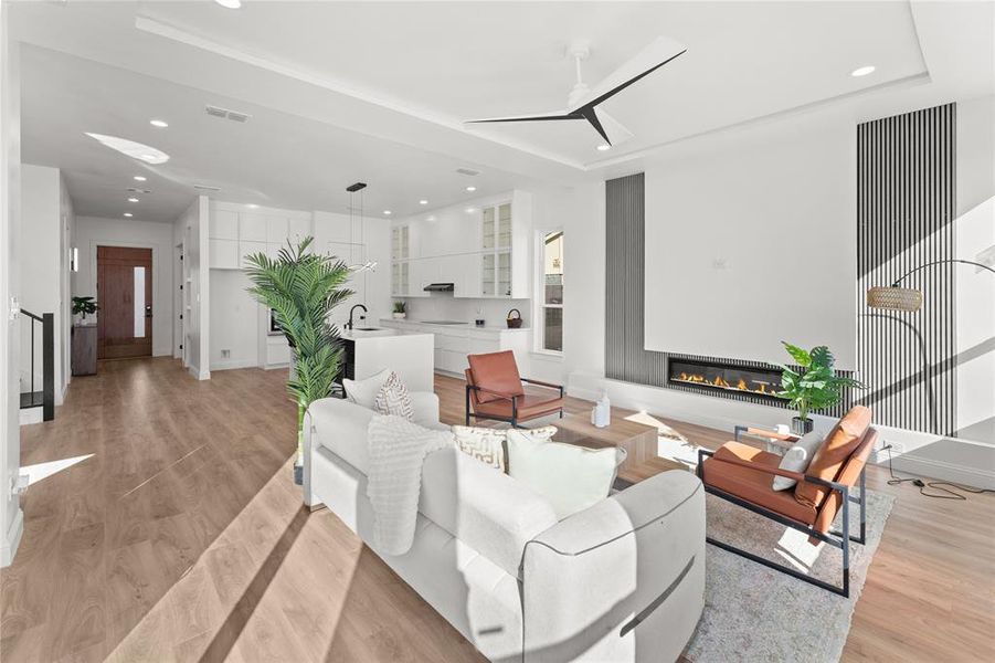 Living area with recessed lighting, light wood-style flooring, a glass covered fireplace, and ceiling fan