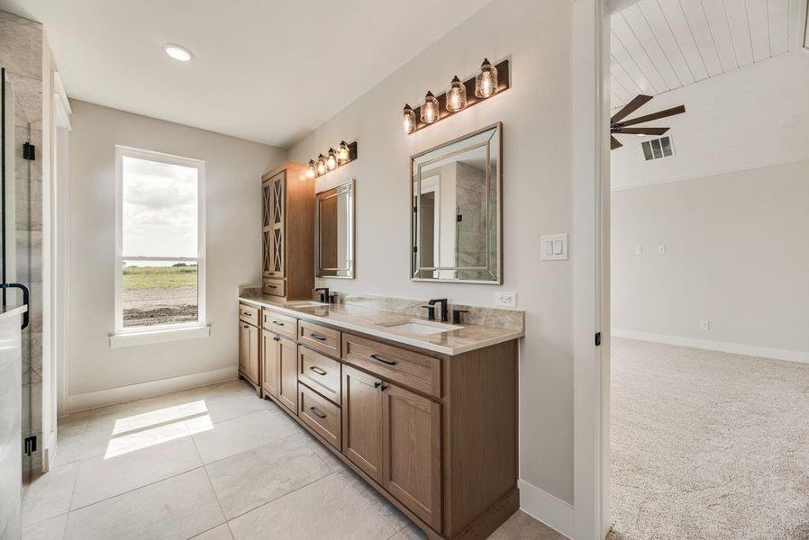 Full bathroom with double vanity, ceiling fan, tile patterned flooring, vaulted ceiling, and an enclosed shower Full bathroom with double vanity, ceiling fan, tile patterned flooring, vaulted ceiling, and an enclosed shower