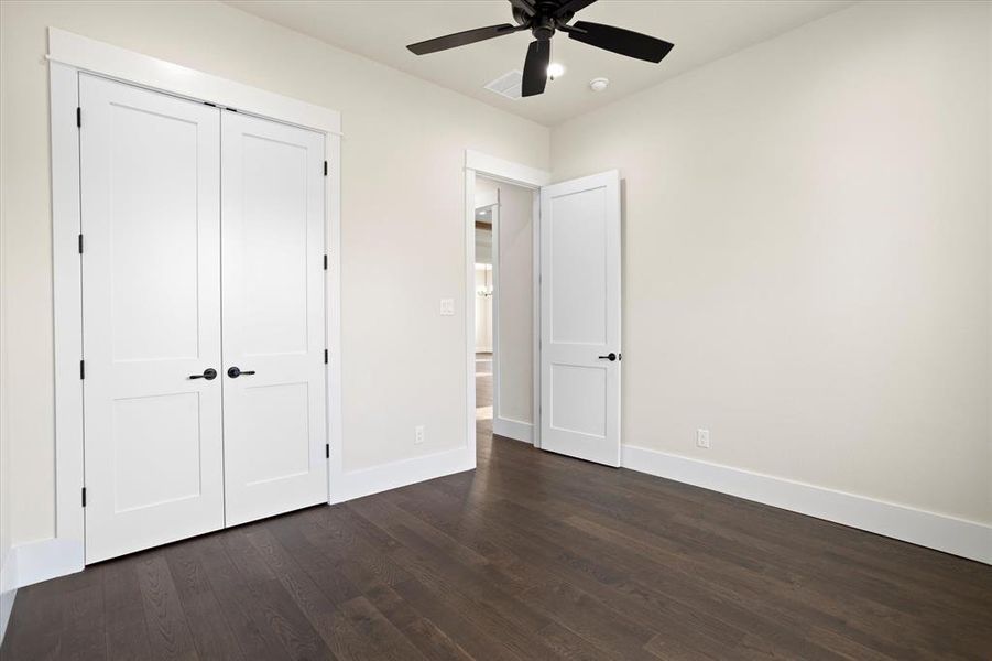 Unfurnished bedroom with a closet, ceiling fan, and dark hardwood / wood-style flooring