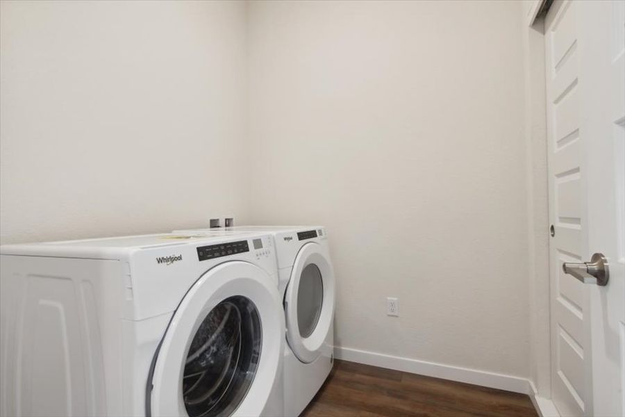 A white washing machine in a room. A white washing machine in a room.