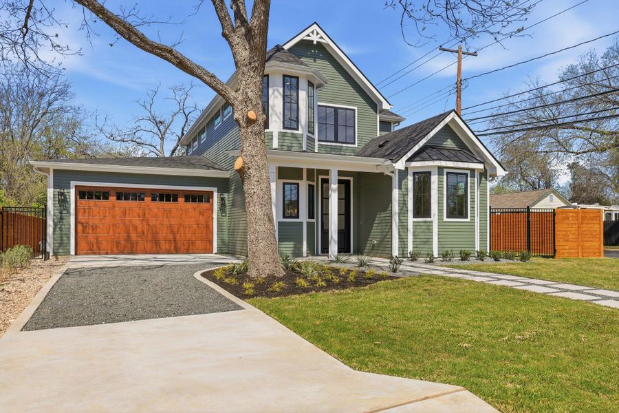 View of front of house featuring covered porch, driveway, and a garage