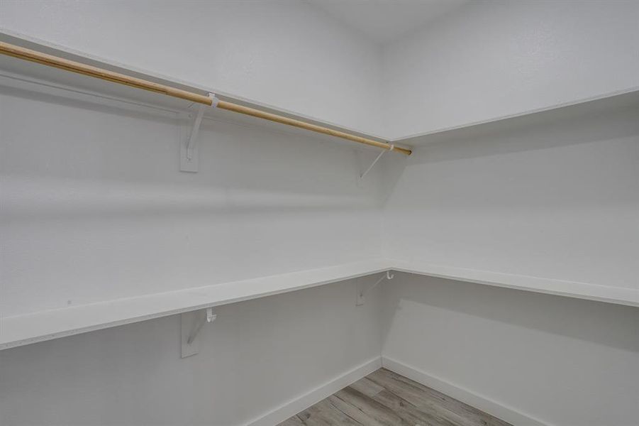 Walk in closet featuring light wood-style floors Walk in closet featuring light wood-style floors