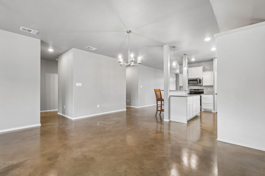 An open-concept living space transitions seamlessly into a well-appointed kitchen, featuring sleek cabinetry and modern finishes. An open-concept living space transitions seamlessly into a well-appointed kitchen, featuring sleek cabinetry and modern finishes.