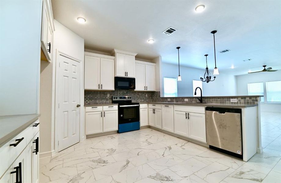 Kitchen featuring ceiling fan, range with electric cooktop, dishwasher, decorative light fixtures, and kitchen peninsula