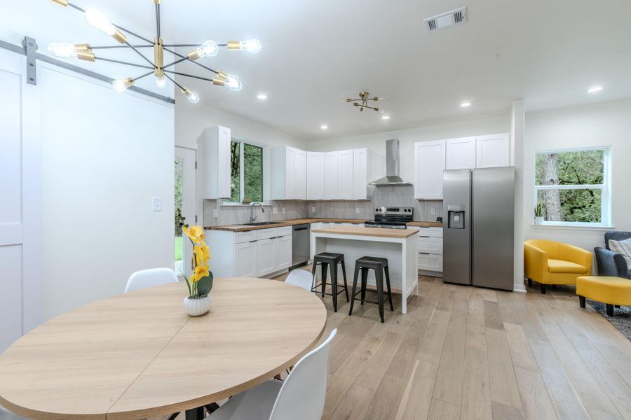 An open-concept living space with a modern kitchen and dining area flows seamlessly into a comfortable lounge. An open-concept living space with a modern kitchen and dining area flows seamlessly into a comfortable lounge.