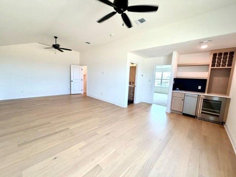 A spacious secondary living area features elegant hardwood flooring and a convenient wet bar. A spacious secondary living area features elegant hardwood flooring and a convenient wet bar.