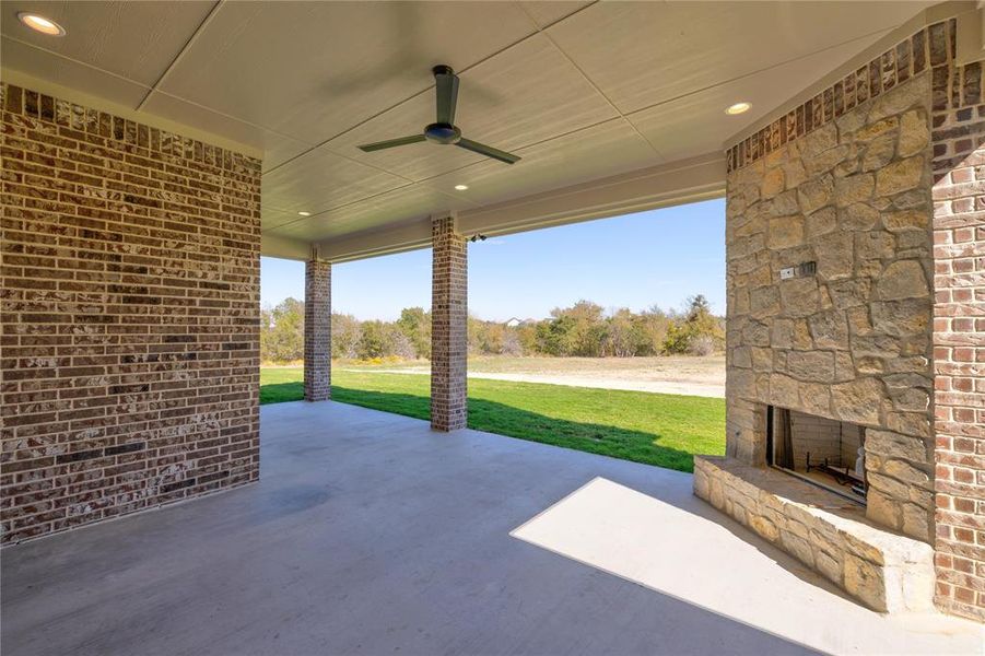 View of patio featuring ceiling fan and an outdoor stone fireplace