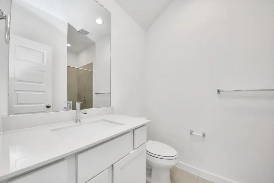 Secondary bath features tile flooring, walk-in shower with tile surround, light stained wood cabinets, beautiful light countertop. Sample photo of completed home with similar floor plan. Actual colors and selections may vary. Secondary bath features tile flooring, walk-in shower with tile surround, light stained wood cabinets, beautiful light countertop. Sample photo of completed home with similar floor plan. Actual colors and selections may vary.