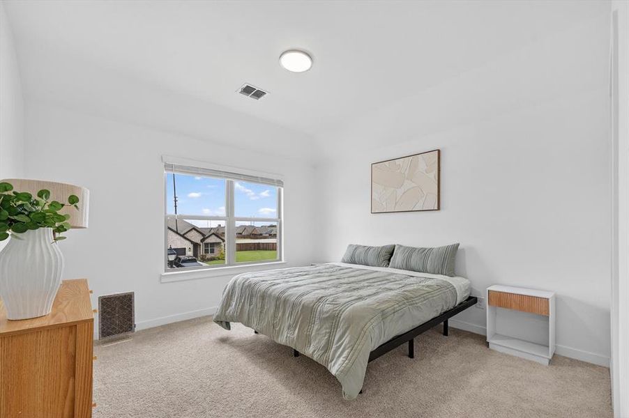 Bright room featuring neutral carpet flooring, a single window with blinds, and recessed ceiling lighting