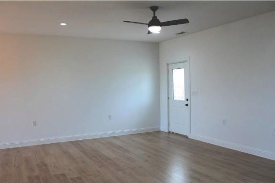 Empty room with light wood-style flooring, a ceiling fan, and recessed lighting Empty room with light wood-style flooring, a ceiling fan, and recessed lighting