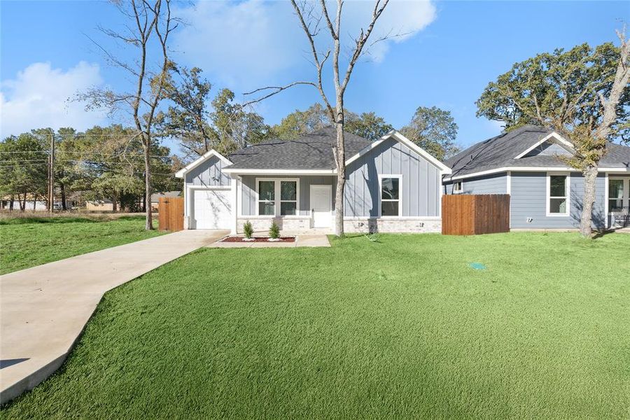 View of front facade featuring a garage and a front yard