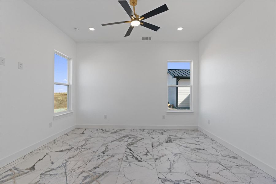 Unfurnished room featuring light marble finish flooring, healthy amount of natural light, recessed lighting, and a ceiling fan