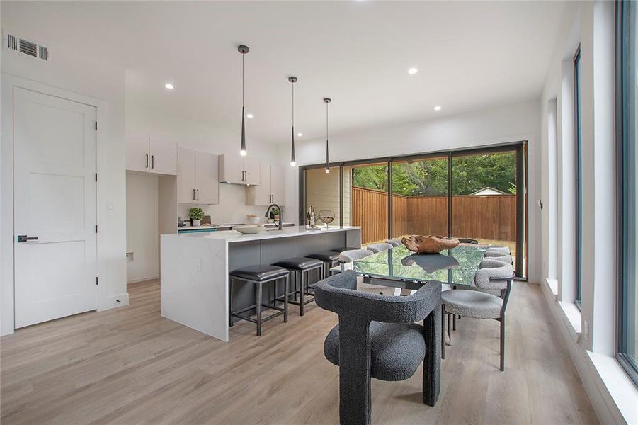 Dining space with light hardwood / wood-style flooring and sink