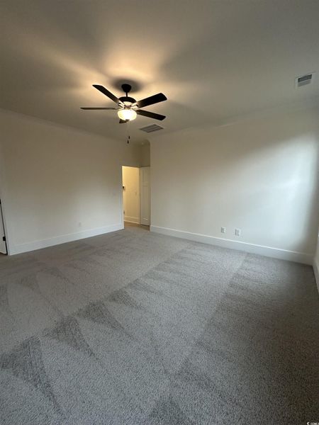 Unfurnished room featuring light carpet and a ceiling fan