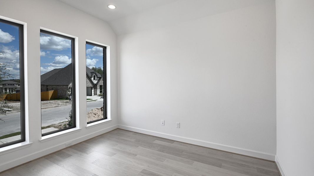 Empty room featuring light wood-style floors, vaulted ceiling, and recessed lighting Empty room featuring light wood-style floors, vaulted ceiling, and recessed lighting