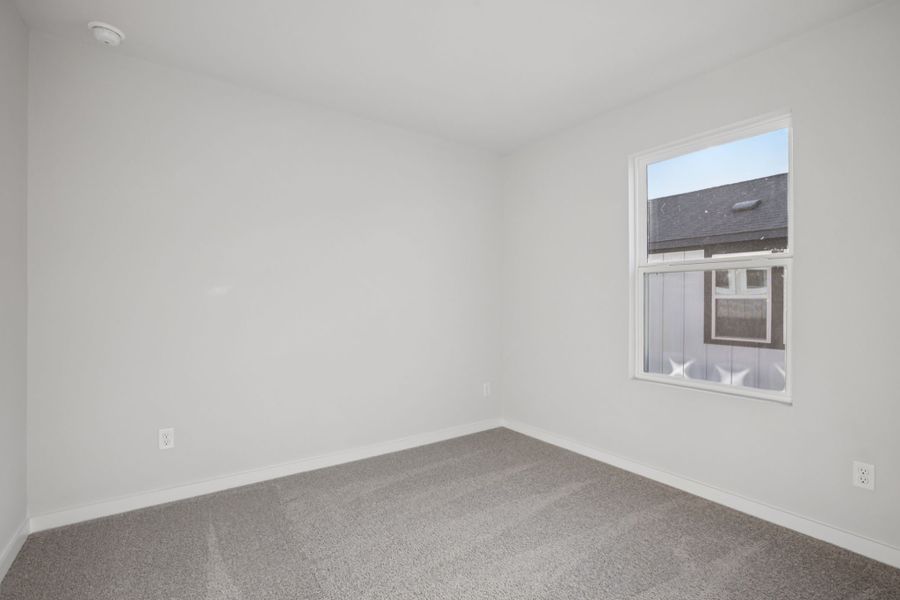 A room with a window and a white wall.