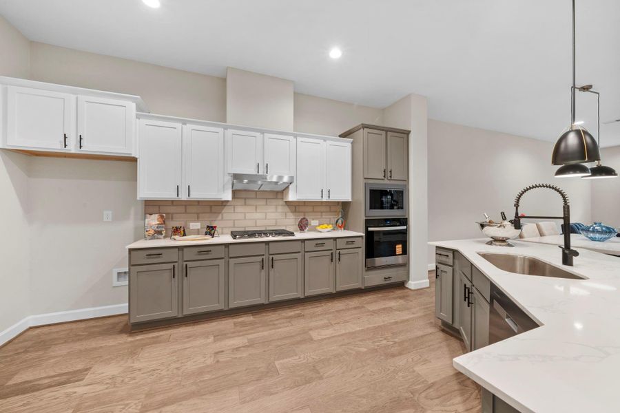 Open kitchen featuring generous counter space, modern cabinetry, and an efficient layout ideal for everyday use. Image depicts home as-is.