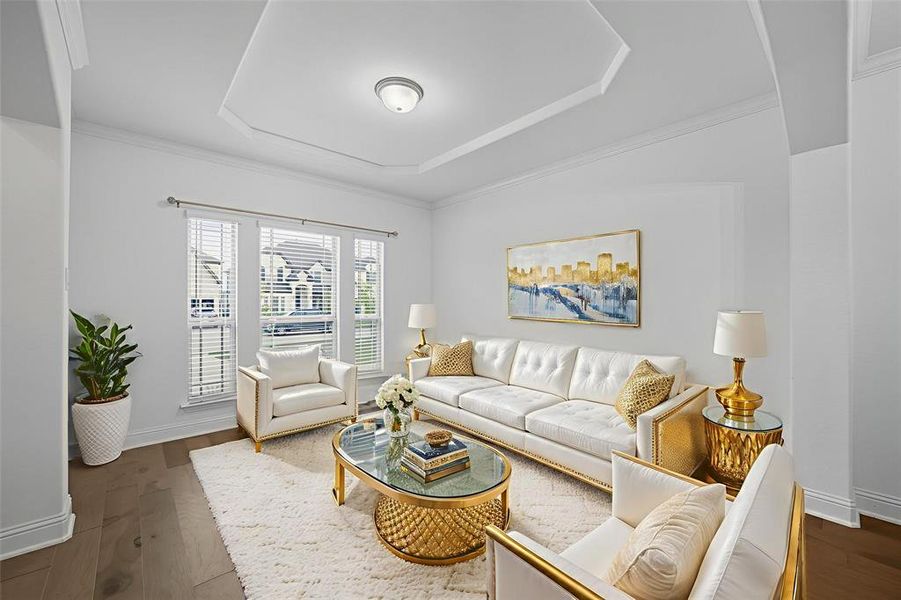 Living area with dark wood finished floors, a raised ceiling, and crown molding Living area with dark wood finished floors, a raised ceiling, and crown molding
