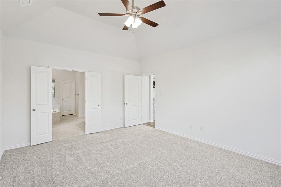 Unfurnished bedroom featuring light colored carpet, high vaulted ceiling, and ceiling fan