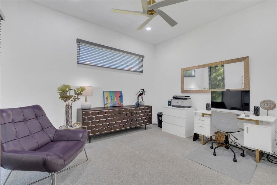 Carpeted office with a ceiling fan and recessed lighting