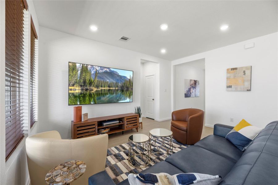 Alternate view of living area showcasing open layout and recessed lighting.