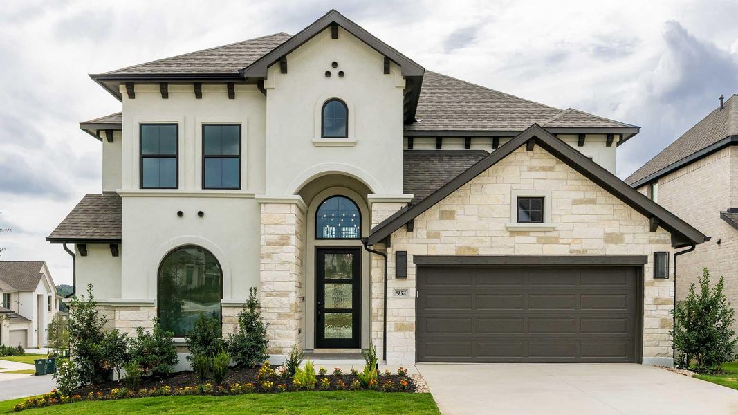 French country home with stone siding, roof with shingles, and stucco siding
