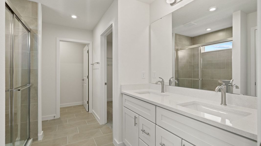 Elegant primary bath features a spacious double vanity, glass shower, and sleek finishes for a relaxing retreat