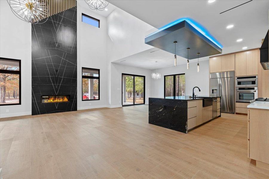 Open concept Living Dining areas with multiple chandeliers, accent lighting, floor to ceiling fireplace. Open concept Living Dining areas with multiple chandeliers, accent lighting, floor to ceiling fireplace.