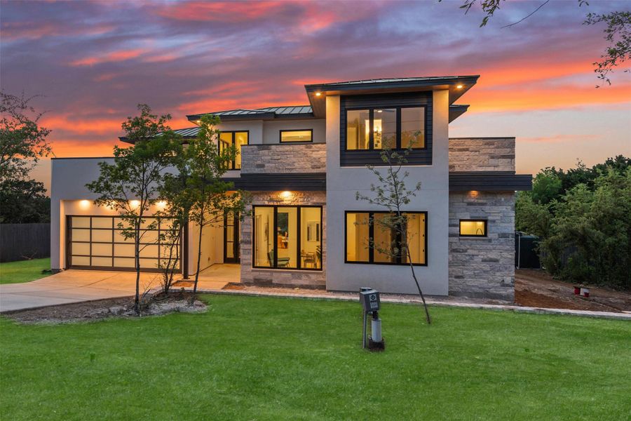 Same floor plan home similar to one being built. View of front of home with a standing seam roof,  stucco and stone siding.