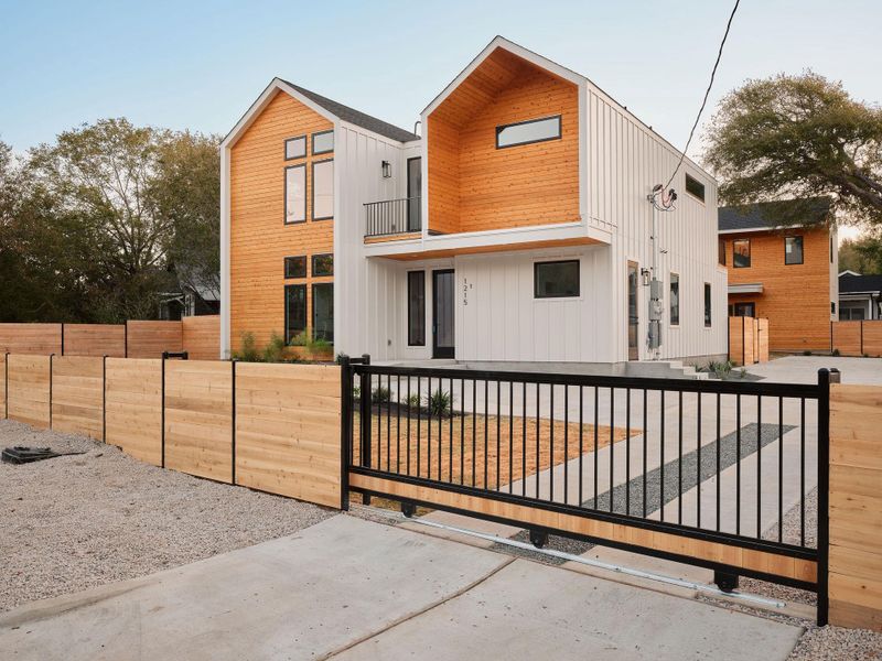 View of front of property featuring a fenced front yard, a balcony, a gate, and board and batten siding View of front of property featuring a fenced front yard, a balcony, a gate, and board and batten siding