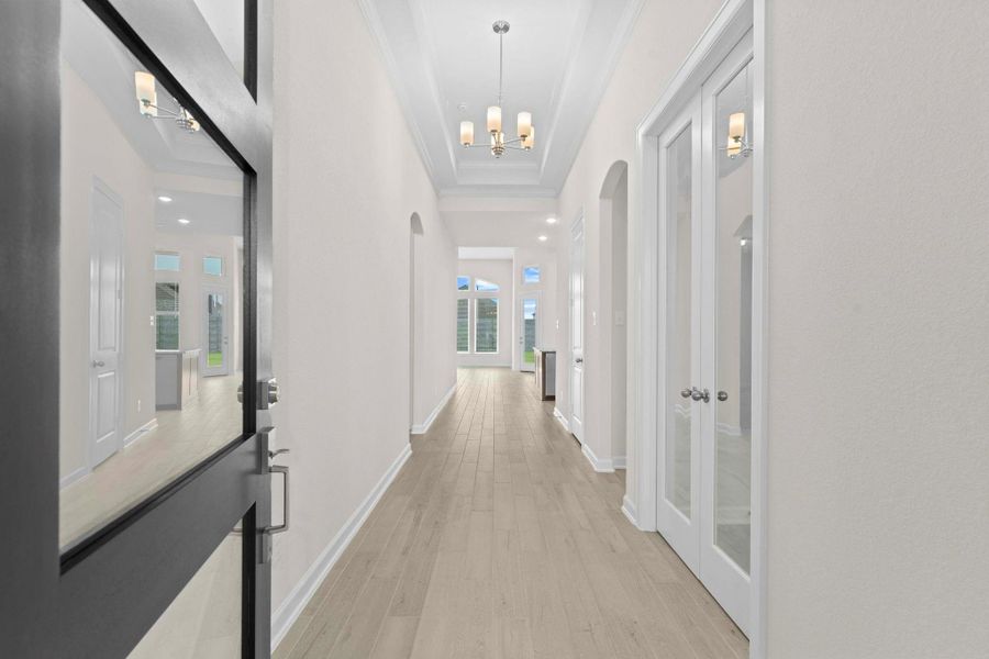 Step inside to a grand foyer featuring soaring ceilings, designer light fixtures, and an open view into the heart of the home, immediately setting a bright and inviting atmosphere.  Wow factor when you walk in with the high coffered ceilings trimmed with crown molding, the beautiful large plank tile floors that look just like wood but so easy upkeep!  Simply stunning entrance to welcome your guest into your home.