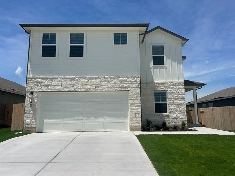 View of front facade featuring stone siding, concrete driveway, board and batten siding, and an attached garage View of front facade featuring stone siding, concrete driveway, board and batten siding, and an attached garage