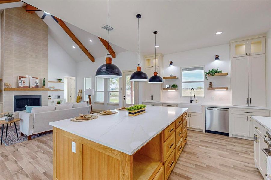 Kitchen with a center island, plenty of natural light, beamed ceiling, sink, and stainless steel dishwasher