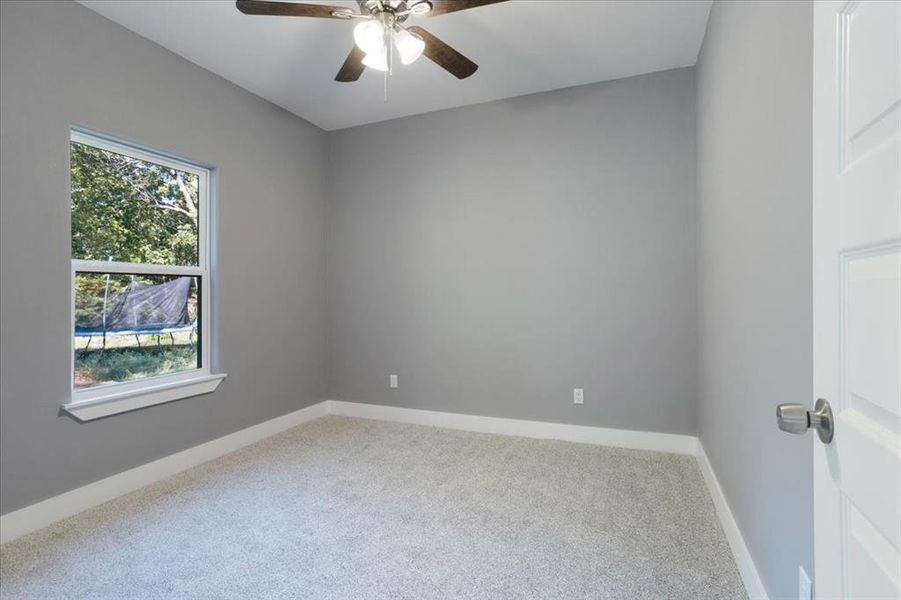 Carpeted spare room with ceiling fan