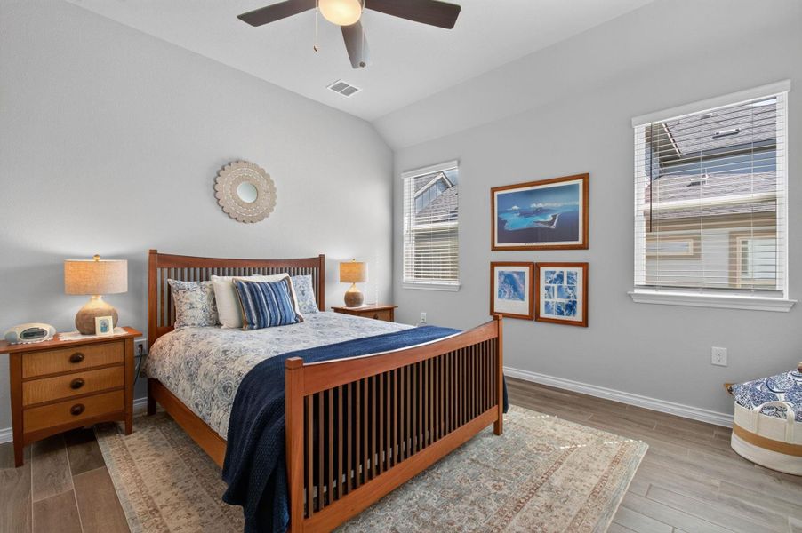 A well-lit bedroom with soaring vaulted ceilings offers ample space and comfort. A well-lit bedroom with soaring vaulted ceilings offers ample space and comfort.