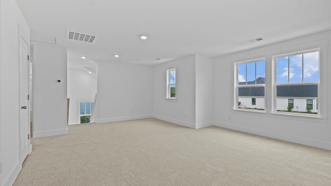 Elegant, carpeted loft that adds a superior layer of flexibility to the home’s design
